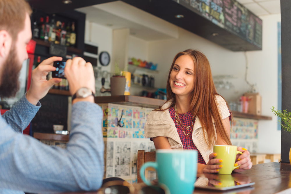 Woman being photographed naturally in a cozy coffee shop during a vibe session